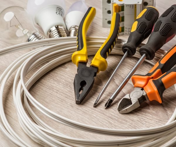 A set of tools electrician, a coil of wire and equipment on a white background